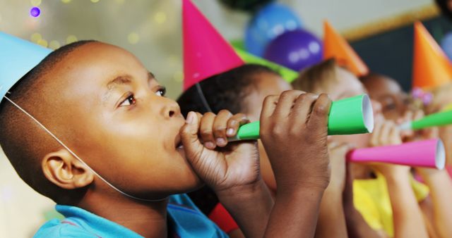 African American boy joyfully blows a horn at a vibrant children's party. - Download Free Stock Photos Pikwizard.com