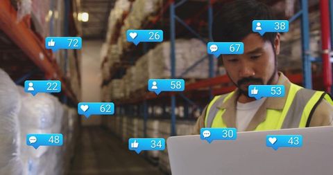 Warehouse worker using laptop with social media overlays for logistics analytics