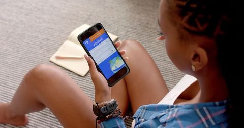 Woman Booking Travel on Smartphone in Relaxing Setting
