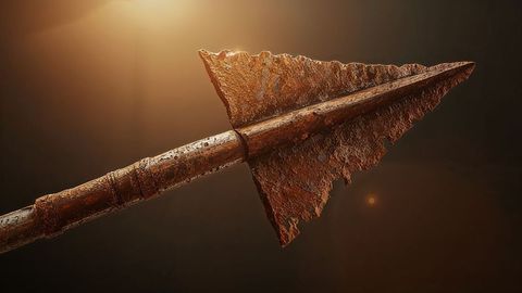 Corroded triangular spearhead with antique rust texture in warm lighting