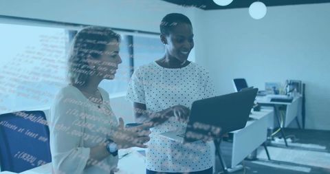 Collaborative teamwork with two women reviewing code in modern office