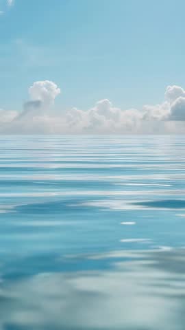 Vertical calming ocean horizon with breeze creating gentle ripples and cumulus cloud bank