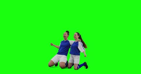 Female Soccer Teammates Kneeling Celebrating Victory Hugging and Raising Fists on Green Screen