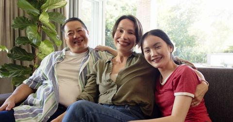 Happy Family Relaxing Together on Cozy Sofa in Bright Living Room