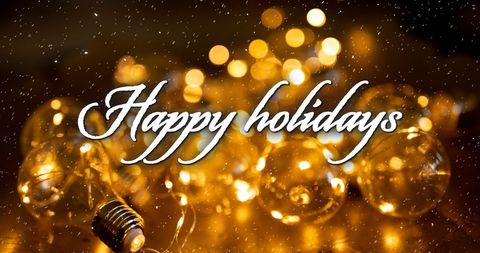 Festive greeting displayed over warm holiday lights