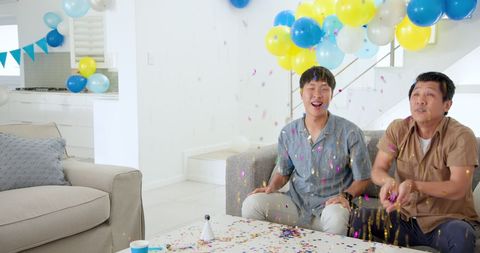 Father and Son Celebrating Joyfully with Confetti