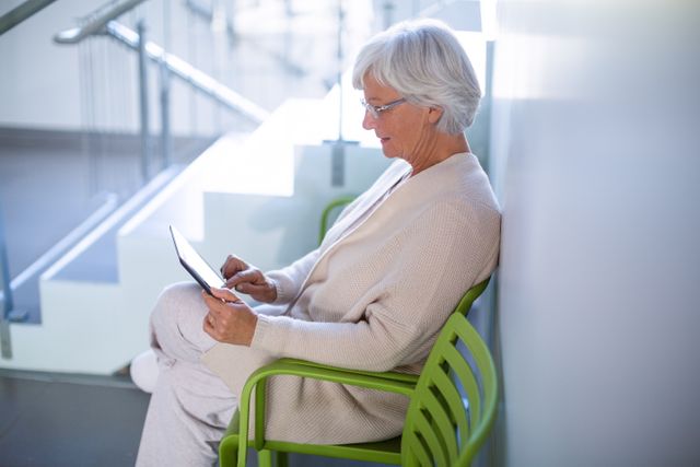 Senior woman using digital tablet in hospital