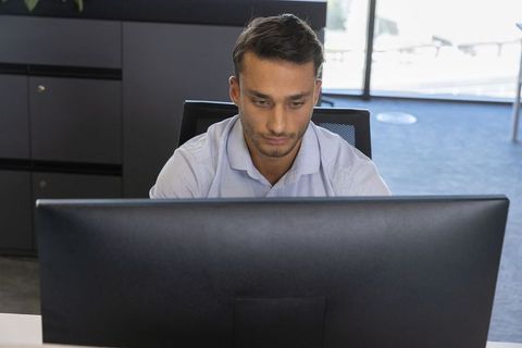 Focused Hispanic Male Professional Working at Office Desk