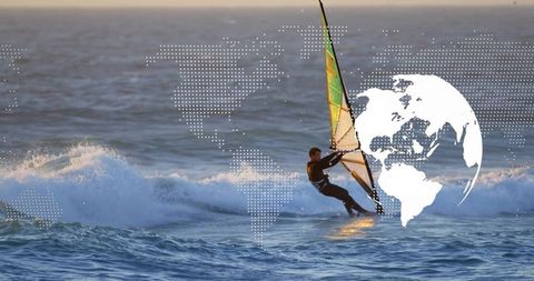 Windsurfer balancing on waves trimming green sail with dotted world map overlay