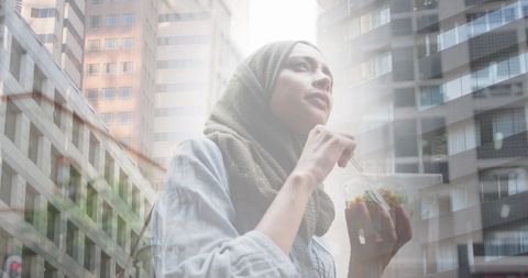 Woman in Hijab Enjoying Salad with Urban Cityscape Overlay