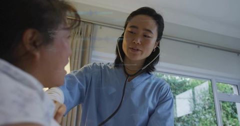 Community nurse examining patient during home visit with stethoscope and natural light