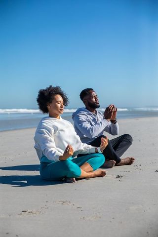 Couple Meditating on Tranquil Ocean Beach