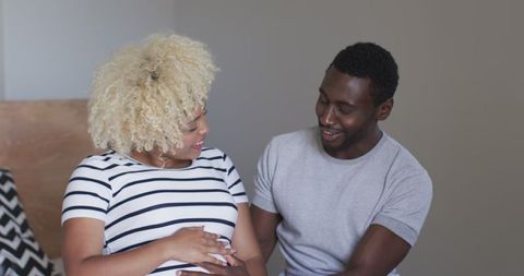 Expectant Couple Experiencing Joyful Pregnancy Moment on Bed
