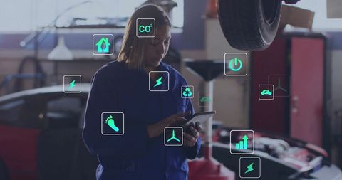 Woman Mechanic Analyzing Car Data with Emission Icons in Workshop