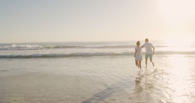 Couple Running on Beach in Sunlight - Download Free Stock Images Pikwizard.com