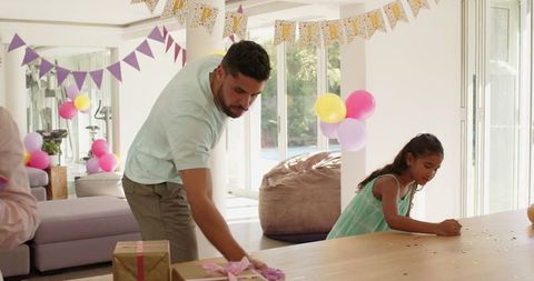 Father Carefully Preparing Party Decorations with Daughter at Home