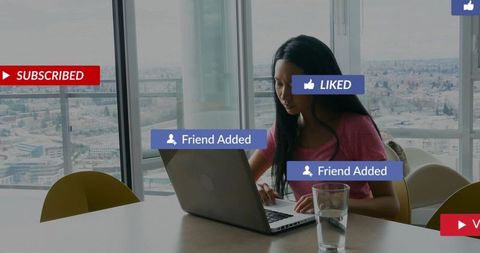 Asian woman working on laptop in highrise with social media notifications and city view