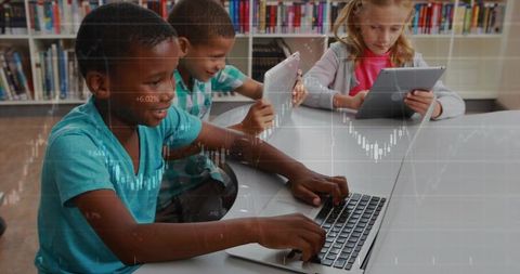 Children learning with laptops and tablets in library striving for academic success