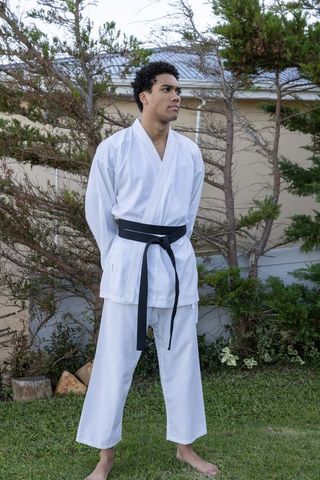 Martial Artist in Gi Reflecting Balance and Discipline Outdoors