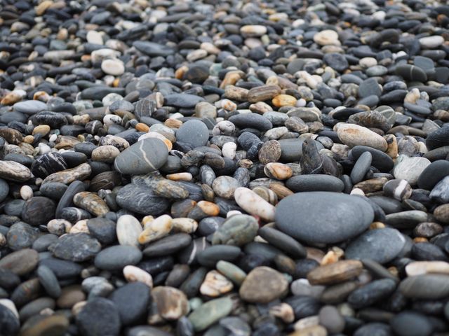 This image of multicolored pebbles on a beach can be used for nature backgrounds, textures, and stock photos related to coastal themes. Ideal for websites, blogs, or promotional materials related to travel, relaxation, and nature. Suitable for decorative purposes, including wallpaper, posters, and digital graphics design.