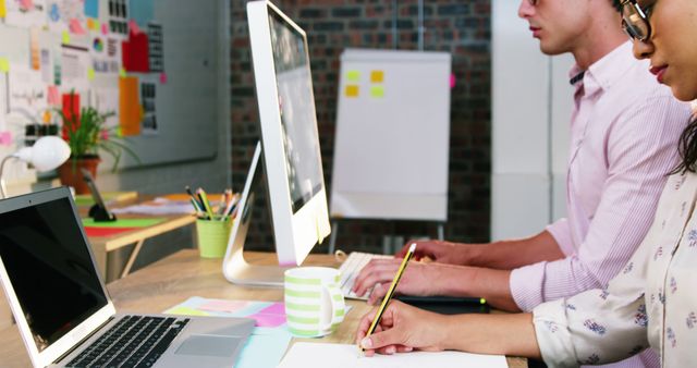 Portrait of businesswoman sitting with coworker while working on computer in office 4k