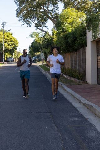 Two Male Friends Jogging on Suburban Street in Bright Daylight