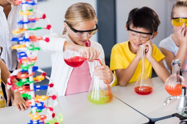 Pupil doing science while classmates looking her in classroom
