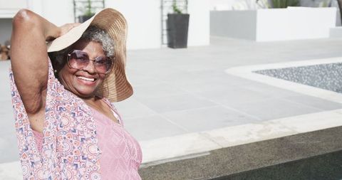 Joyful Senior Woman Relaxing Outdoors in Sun Hat