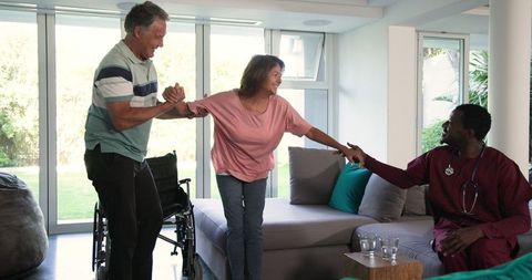 Senior Couple Engages with Caregiver at Home in Cheerful Interaction