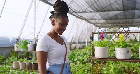 Woman Enjoying Plants in Modern Eco-Friendly Greenhouse