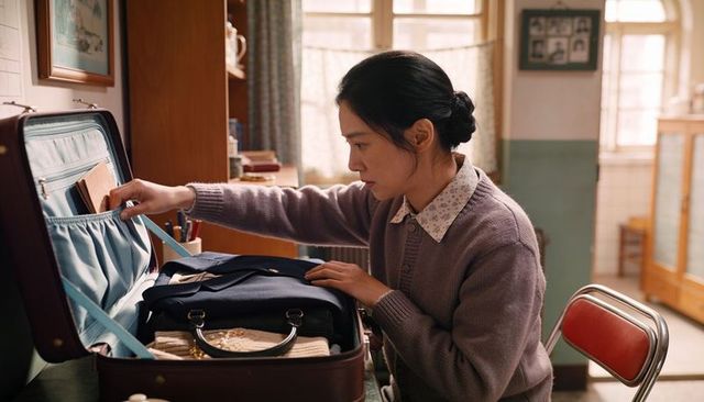 Woman packing vintage suitcase at home, organizing luggage and personal items