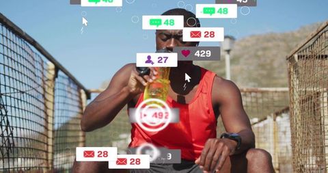 Male athlete drinking water during outdoor workout with smartwatch and social notifications