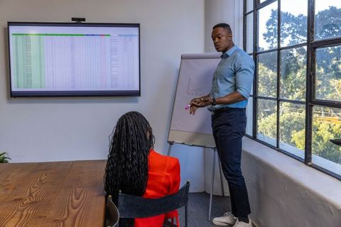 African american colleagues analyzing graphic presentation in meeting room