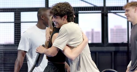 Athletes hugging team spirit elevated on urban court