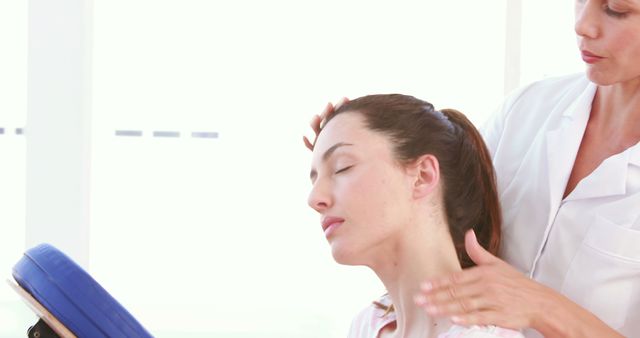 Professional therapist massaging woman’s neck and upper back in a calming setting. Ideal for use in health and wellness promotions, spa advertisements, physical therapy marketing, and articles on stress relief and rehabilitation.