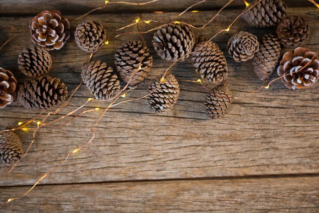 Pine Cones with Christmas Lights on Wooden Plank - Download Free Stock Photos Pikwizard.com