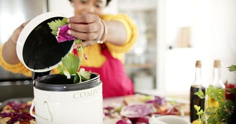 Smiling Woman Composting Vegetable Scraps for Sustainable Living