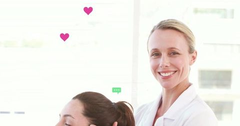 Smiling female clinician offering supportive head hold during consultation in bright clinic