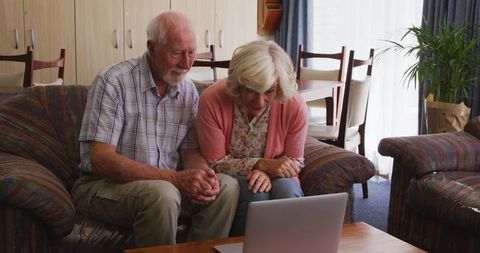 Senior Couple Video Calling Family on Laptop at Home