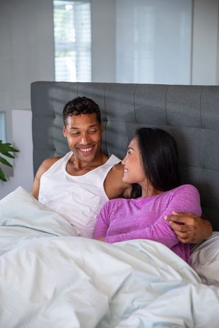 Romantic Interracial Couple Relaxing Together in Cozy Bedroom