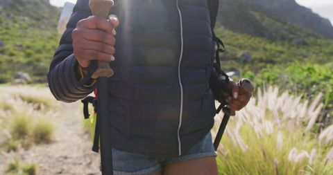 Close-up of Woman Hiking with Trekking Poles in Mountain Scenery