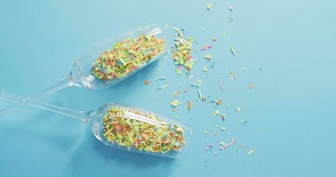 Colored Confetti in Champagne Glasses on Blue Background