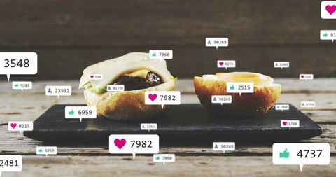 Gourmet slider halves resting on slate, floating social media likes and engagement badges