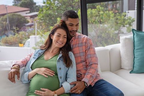 Expectant Couple Sharing Intimate Moment on Sofa