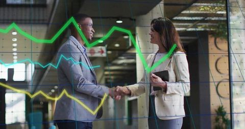 Business partners shaking hands in modern office lobby with data visualization overlay