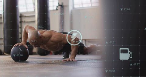 Bald athlete performing one-arm medicine ball pushup with hud fitness overlay strength workout