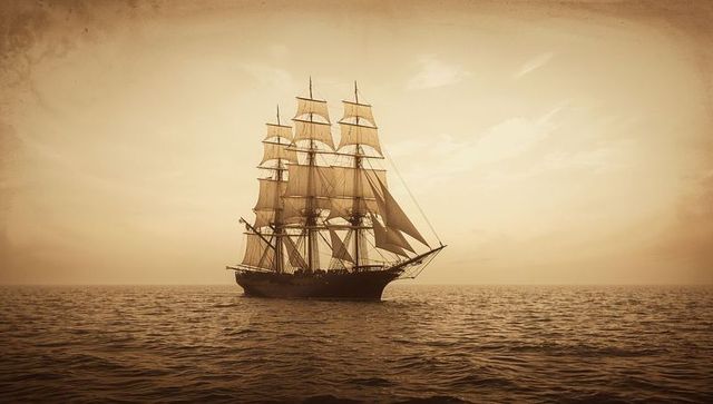 Historical tall ship sailing on open ocean at dusk