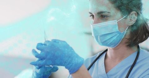 Nurse preparing vaccine syringe wearing mask and gloves in clinic