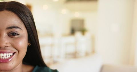 African american woman smiling in modern kitchen with soft bokeh and copy space