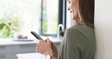 Middle-Aged Woman Enjoying Phone Connection at Home